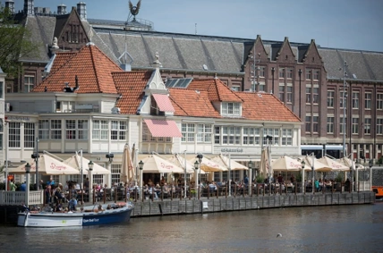 Terras aan het water bij restaurant Loetje aan de De Ruijterkade in Amsterdam op een zonnige dag.